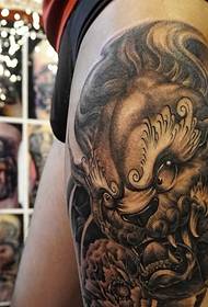 Vecchio modello tradizionale del tatuaggio totem sulla parte esterna della coscia