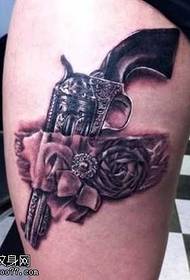motivo tatuaggio rosa gamba pistola