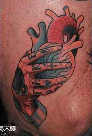 gambe a mano afferrando il modello del tatuaggio del cuore