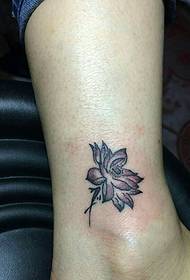 et monotont lite lotus-tatoveringsmønster på leggen