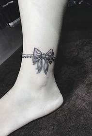 La foto del tatuaggio con fiocco grigio nero sulla caviglia è molto bella