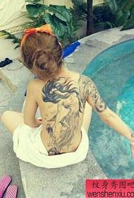 usa ka babaye nga puno sa likod nga sumbanan sa tattoo nga sirena