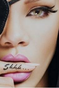 Rihanna qo'lidagi tatuirovka qora ingliz alifbosi zarb rasmlariga yulduz barmog'i
