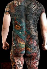 L'esquena dominava a un guapo súper guapo ple de patrons de tatuatge de prajna i drac