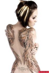 Donna creativa con ali posteriori piene di tatuaggi