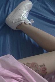 Tatuaggio rosa incombente sulla coscia delle ragazze