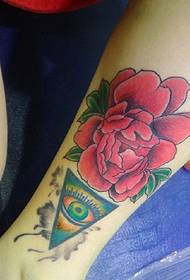 un tatuaggio fiore rosso vivo sul polpaccio