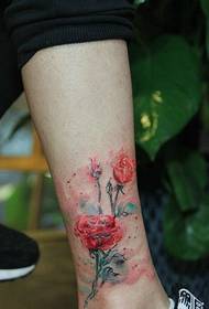 Foto de tatuaje de flor de acuarela que cae sobre la pantorrilla