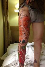 красная большая татуировка кальмара, покрывающая всю ногу