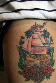 Muodikkaat naisjalat hienolla värillisellä purjeveneen tatuoinnilla