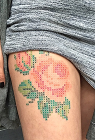 vrouwelijke been rose kruissteek tattoo