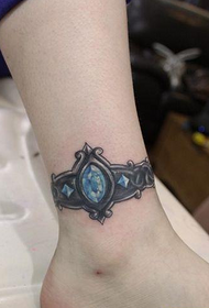 femmina Un disegno del tatuaggio ad anello del piede ingioiellato sulla gamba del bambino