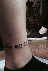 una piccola parola inglese tatuaggio nel polpaccio