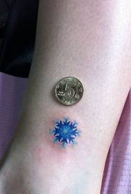 naisen jalka pieni värikäs lumihiutale tatuointi