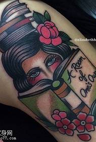 Jeune femme lisant un tatouage sur la cuisse