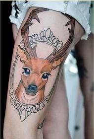 Jambes féminines avec de jolies photos de motifs de tatouage d'antilopes colorées