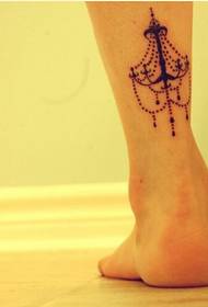 Las piernas de las niñas solo miran las imágenes del patrón de tatuaje de la lámpara de tótem