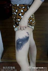 Ampio motivo a tatuaggio con piume striate sulle gambe
