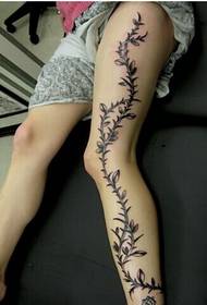 Piernas femeninas de moda, una hermosa y hermosa foto de tatuaje de flor de vid