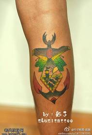 Faro de cor da perna con patrón de tatuaxe de peixe bateo