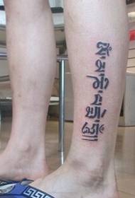 पैरों पर स्टाइलिश व्यक्तित्व के साथ संस्कृत टैटू