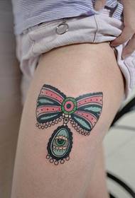 Belle gambe della ragazza, bella immagine del tatuaggio dell'arco di pizzo