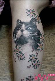 Obraz tatuażu kota i małego kwiatu na łydce