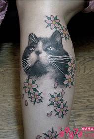 Foto tatuaggio gatto e piccolo fiore sul polpaccio