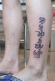 Sanskrit-Tattoo mit stilvoller Persönlichkeit an den Beinen