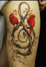 Meiteņu kājas veido glītas piezīmes un putnu tetovējuma attēlus