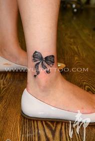 Foto di tatuaggio femminile con fiocco in pizzo alla caviglia