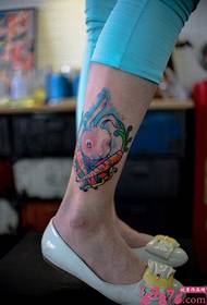 Mali bijeli zec jede slike rotkvica kreativnih tetovaža nogu