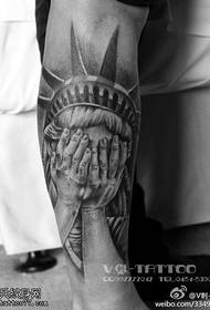 Рукі, якія пакрываюць малюнак татуіроўкі асобы
