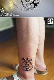 Mini tatuaggio mini arpa sulle gambe