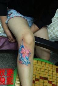 Blou saffloer tattoo prentjie op die knieë van die bene