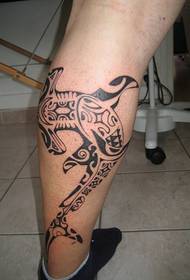 a whale totem tattoo on the calf