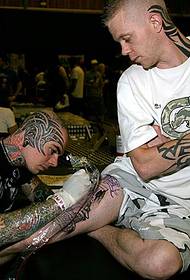 Európai és amerikai tetováló művész láb személyiség tetoválás jelenet