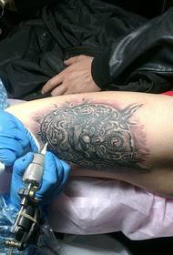Vyro šlaunies pipirų figūros tatuiruotės proceso nuotrauka