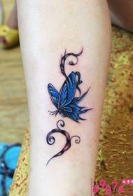 Mergaitės blauzdos mėlynos spalvos drugelio tatuiruotės paveikslėlis