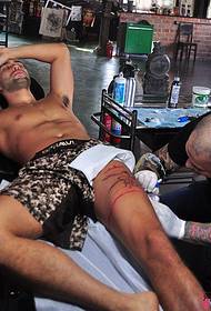 Scena di tatuaggi di tatuale di gamba europea è americana