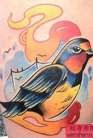 a beautifully colored colorful swallow tattoo on the leg
