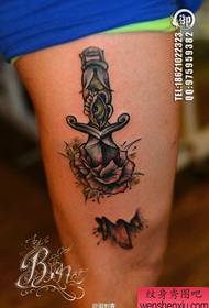 Splendido motivo a tatuaggio rosa con pugnale pop sulle gambe