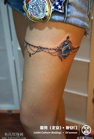 Naisten jalkojen jalkaketjun jalokivi-tatuoinnit tatuoinnin jakamisen avulla