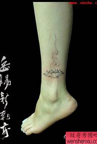 Bellissimo e chiaro disegno del tatuaggio del loto sulle gambe delle ragazze
