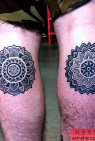 a beautiful geometric flower tattoo on the calf