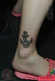 Mergaitės kojos juodos pilkos inkaro tatuiruotė veikia