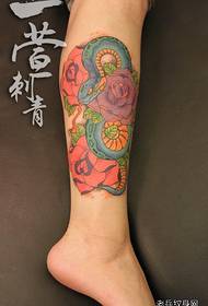 Bellissimo e bellissimo serpente colorato e motivo tatuaggio rosa sulle gambe