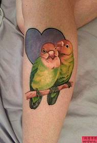 un tatuaggio pappagallo personalizzato sul polpaccio