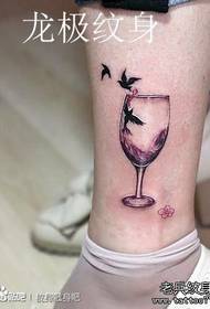 लड़कियों के पैरों में लोकप्रिय एक रेड वाइन ग्लास और बर्ड टैटू पैटर्न