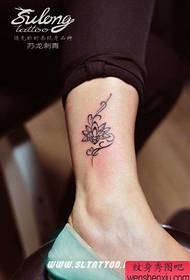 Umlenze wamantombazana amancinci kunye ne-totem lotus tattoo eyaziwayo